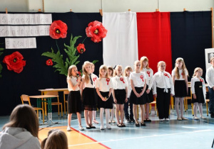 Uczennica śpiewa piosenkę patriotyczną.