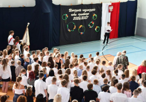Społeczność szkolna śpiewa hymn narodowy.