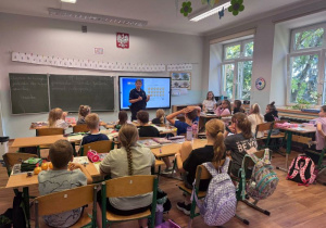 Pani policjantka omawia zasady bezpieczeństwa w drodze do szkoły.