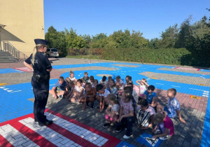 Pani policjantka demonstruje zasady przechodzenia przez przejście dla pieszych.